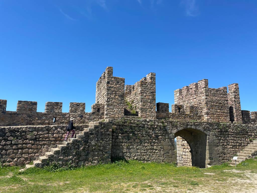 Duas torres, uma escadinha e uma porta nas muralhas do castelo medieval de Arraiolos, em um dia de céu azul