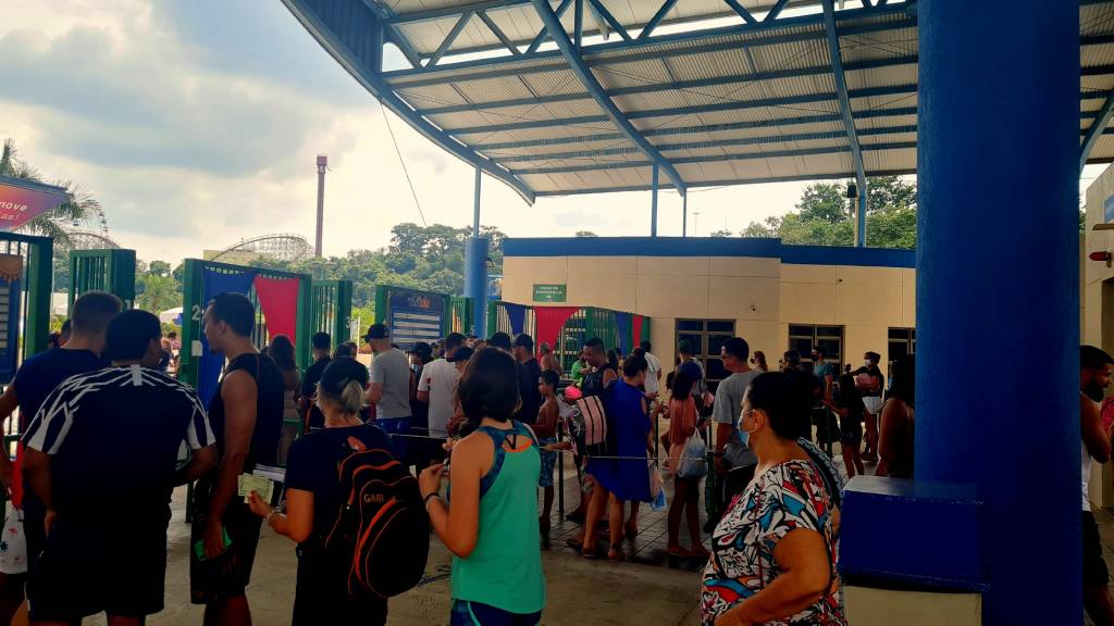 A imagem mostra muitas pessoas em fila para entrar no parque aquático.