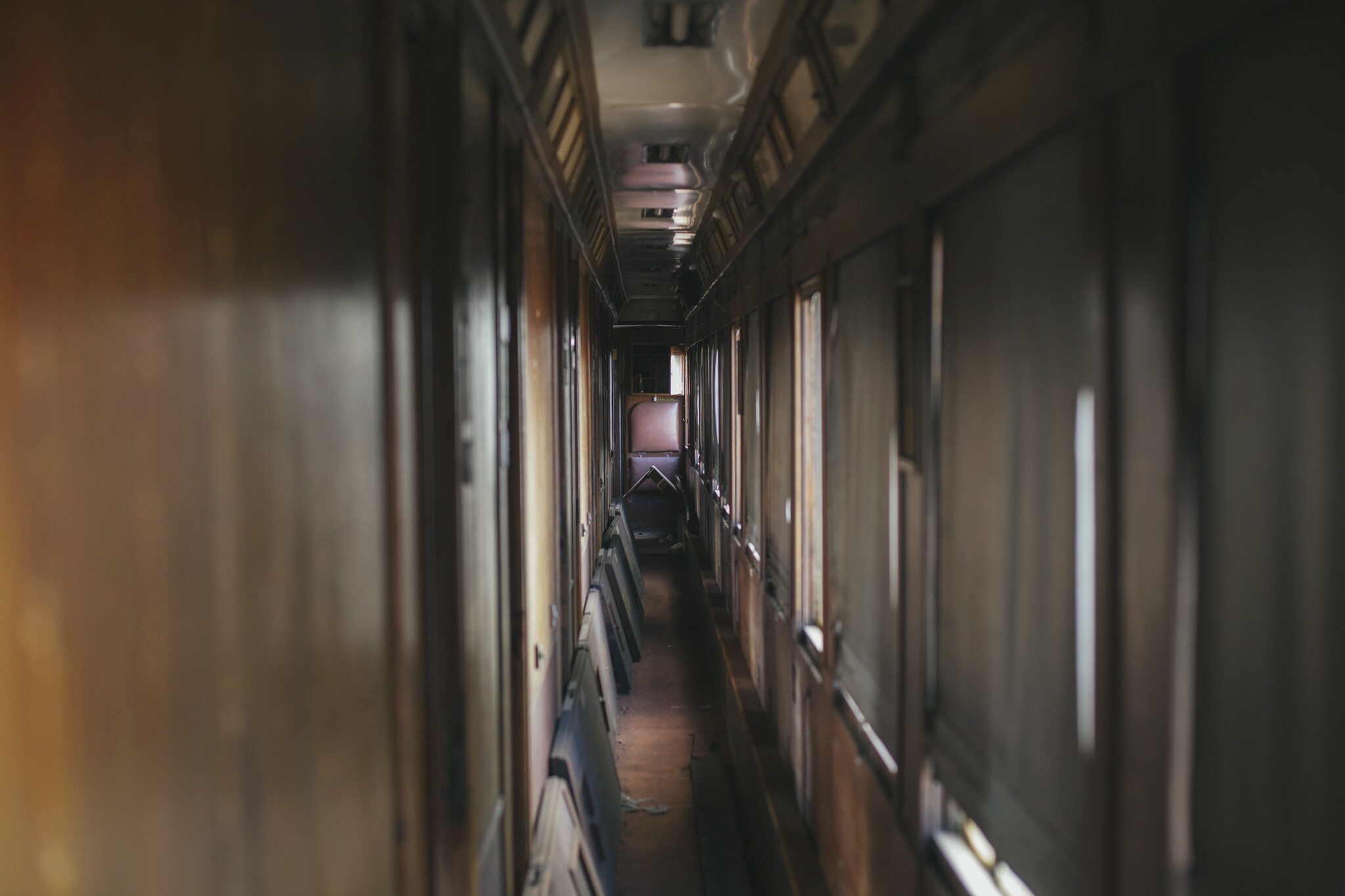 A imagem mostra um corredor escuro com paredes de madeira