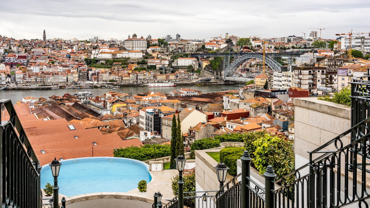 Piscina arredondada, o casario de Gaia, o Douro correndo lá embaixo e, ao fundo, o casario colorido do Porto