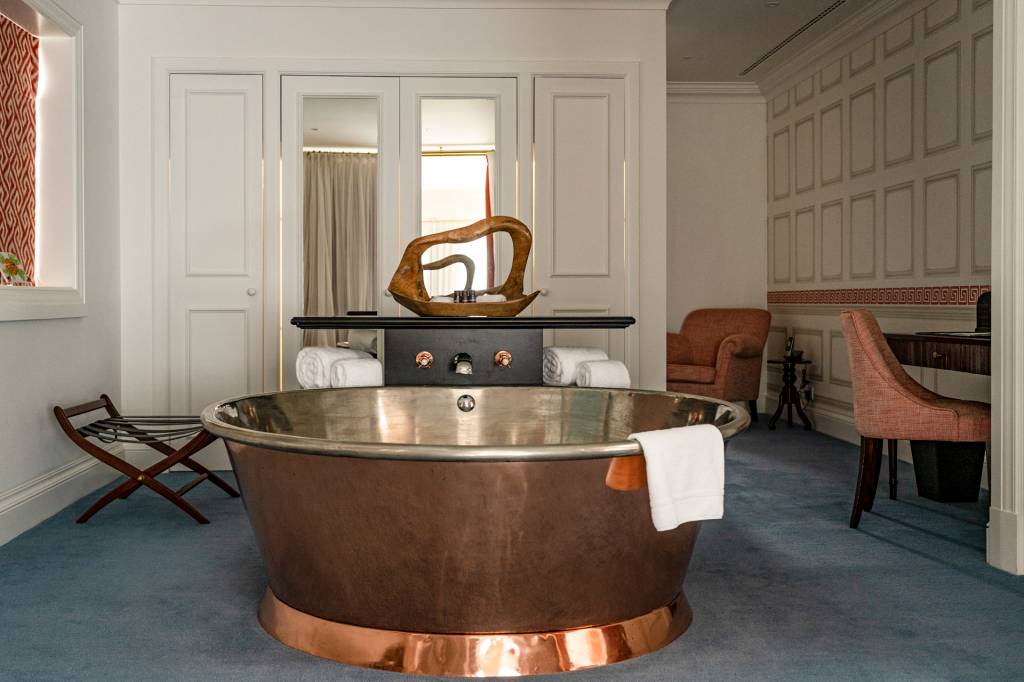 Banheira de cobre em formato de tina de vinho numa suite de hotel