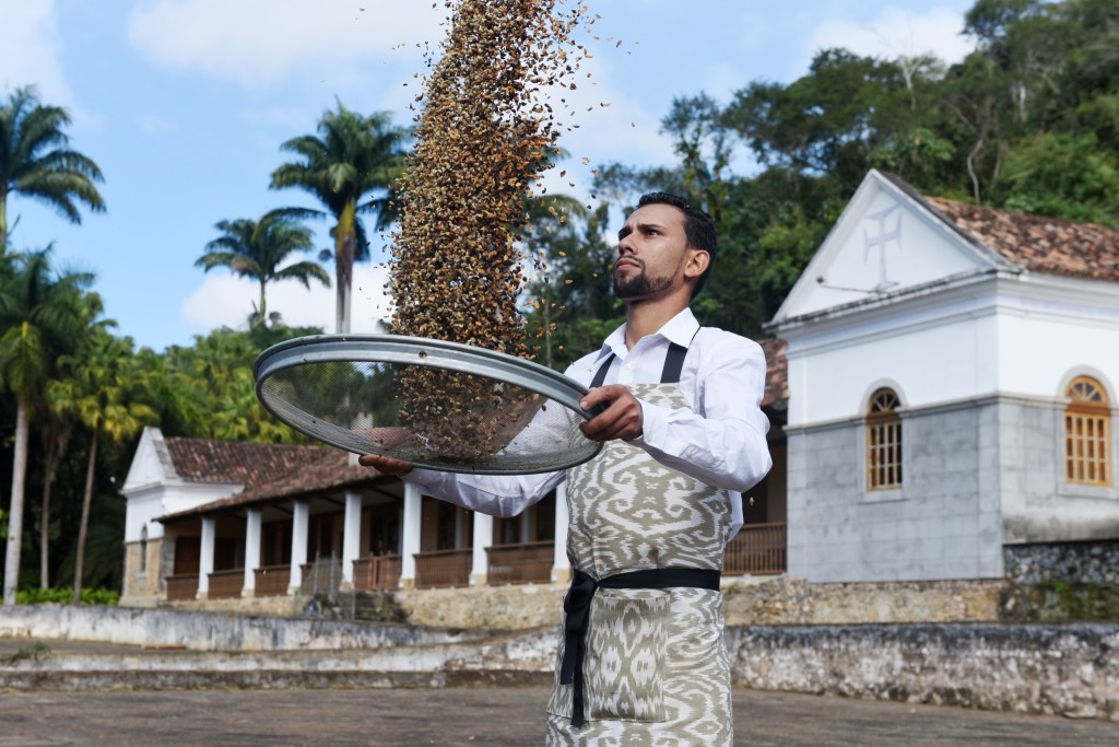 Um homem joga grãos de café para o alto