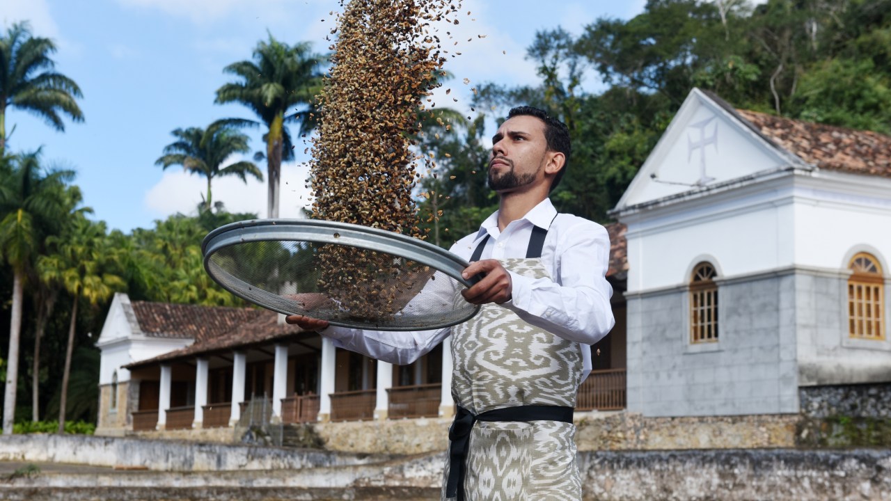 Um homem joga grãos de café para o alto