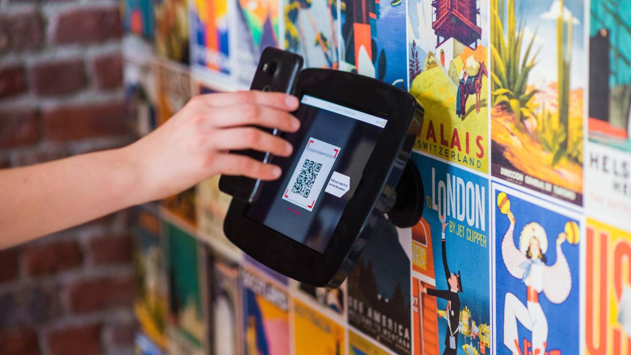celular apontando para QR code em máquina na parede