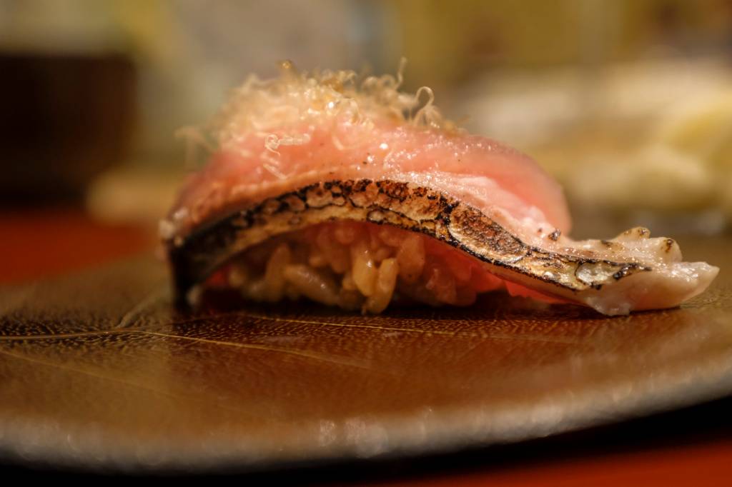 Nigiri: peça da culinária japonesa com base de arroz, fatia de peixe braseado e algas por cima