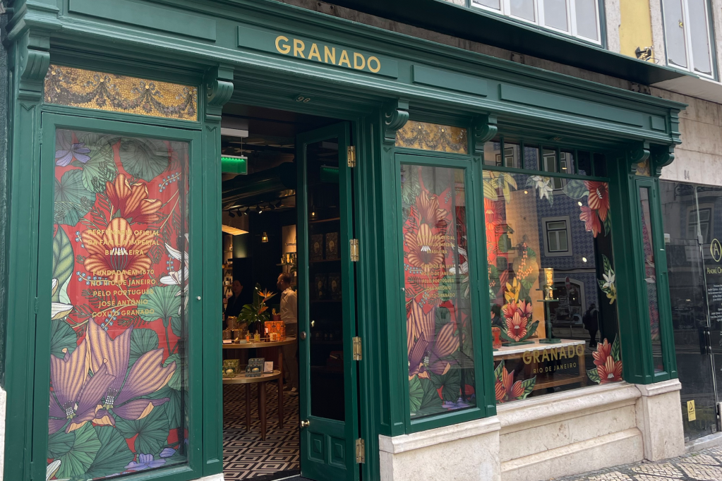 Fachada da loja da Granado em Lisboa, em madeira verde, com o nome da marca em dourado e decoração floral nas vitrines