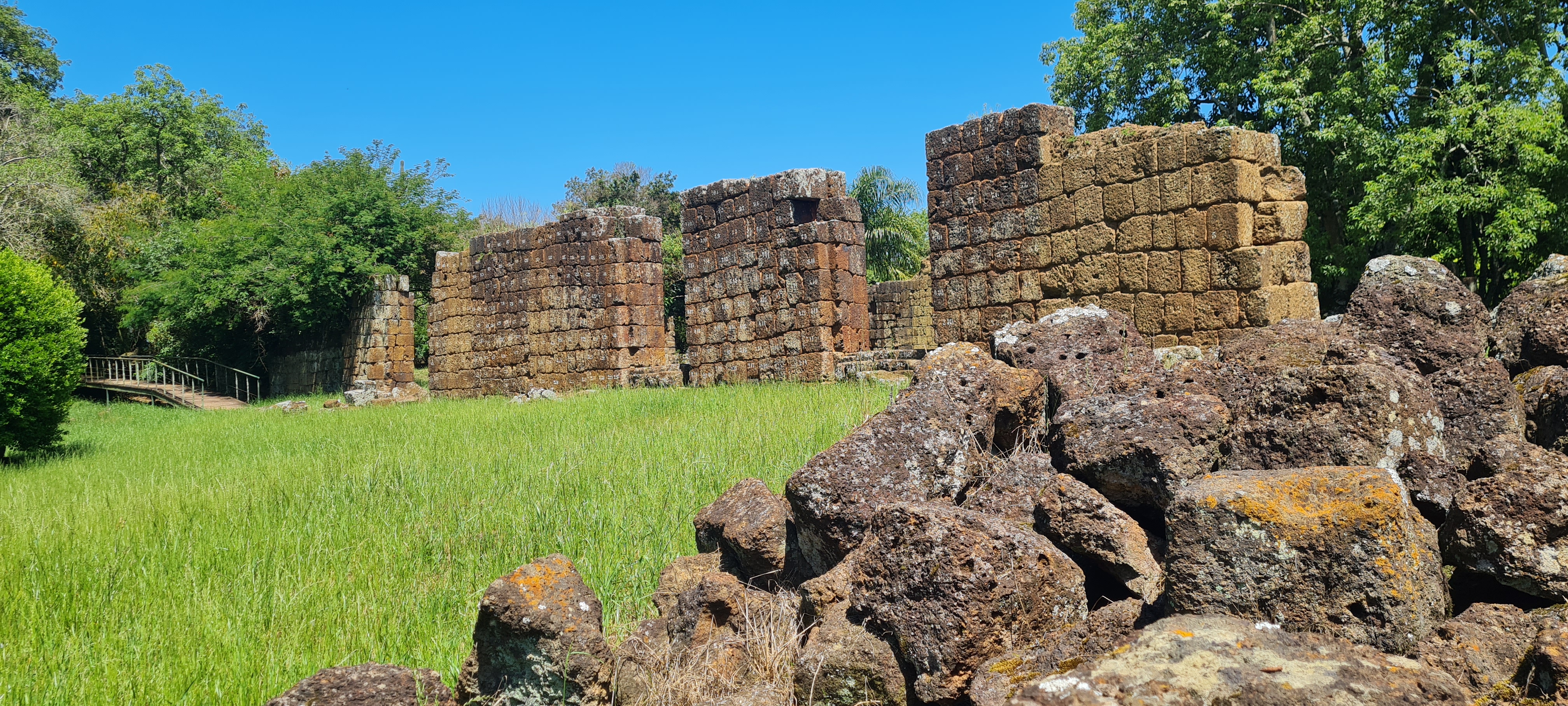A imagem mostra paredes de pedras em ruínas