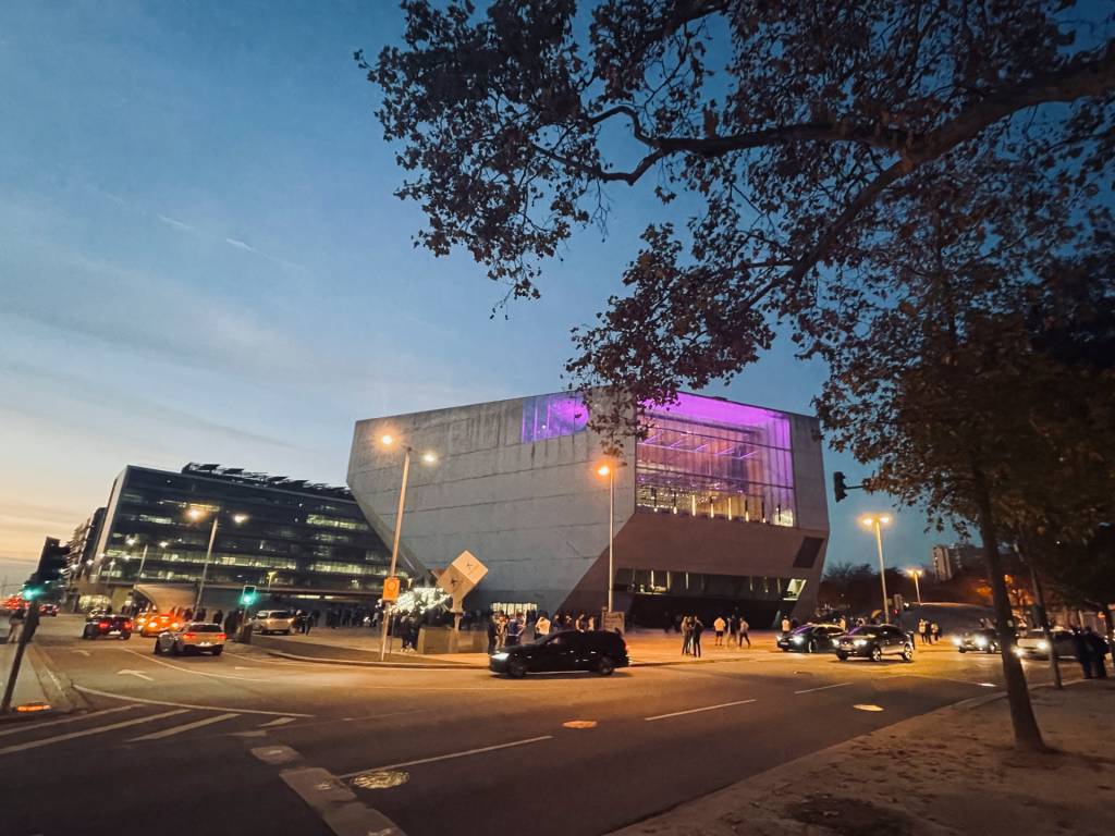 O edifício da Casa da Música, que tem a forma de um diamante, ao fim do diam com uma luz de neon roxa numa das fachadas