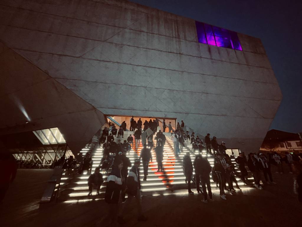 Pessoas sobem uma escasa iluminada para entrar no edicício da Casa da Música