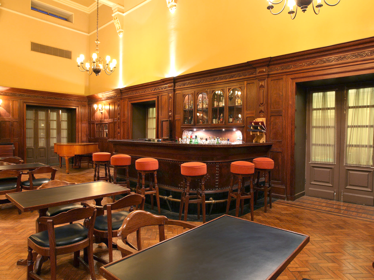 A fotografia mostra um bar com paredes de madeira
