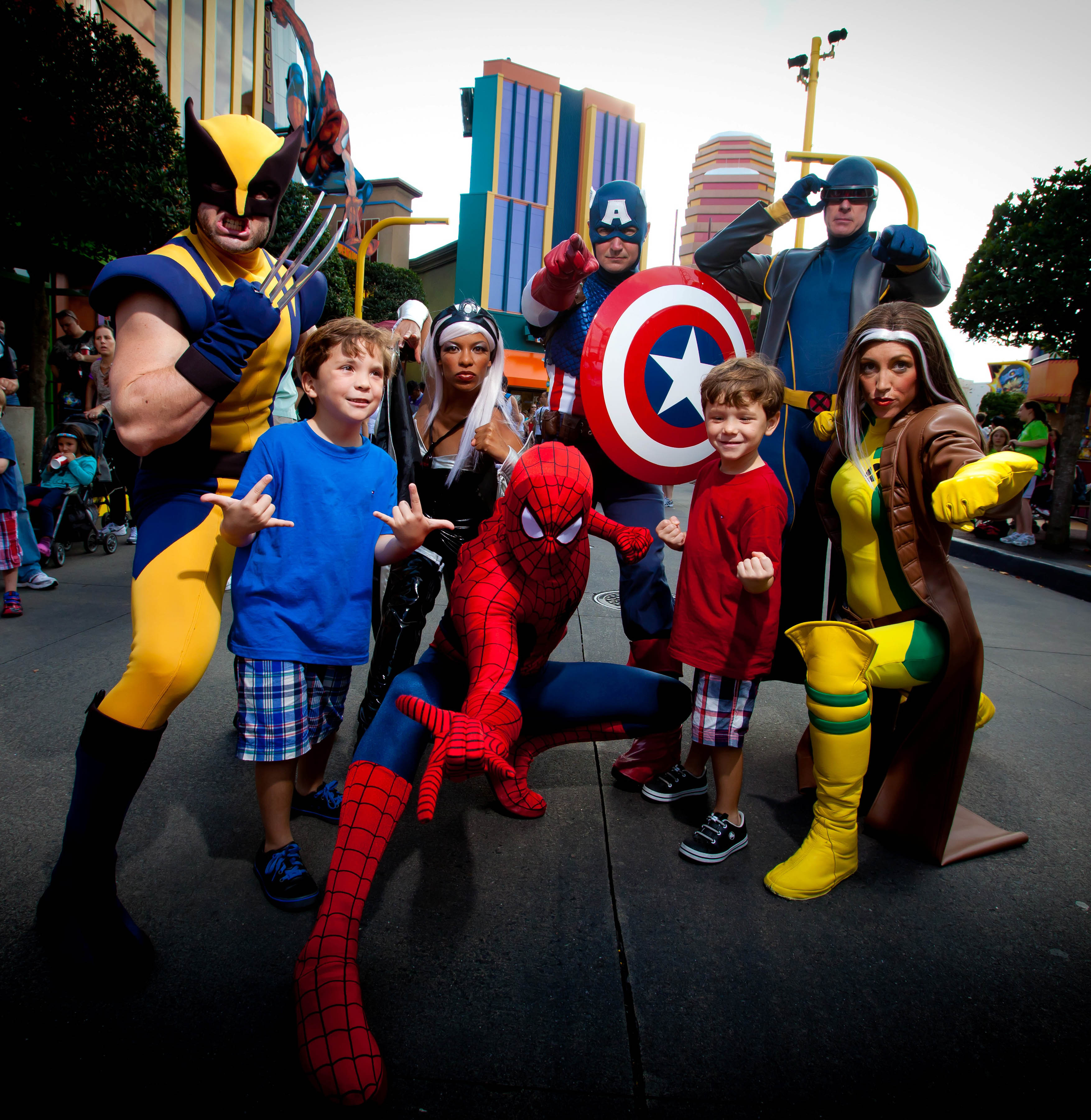 A foto mostra crianças com pessoas vestidas de super-heróis