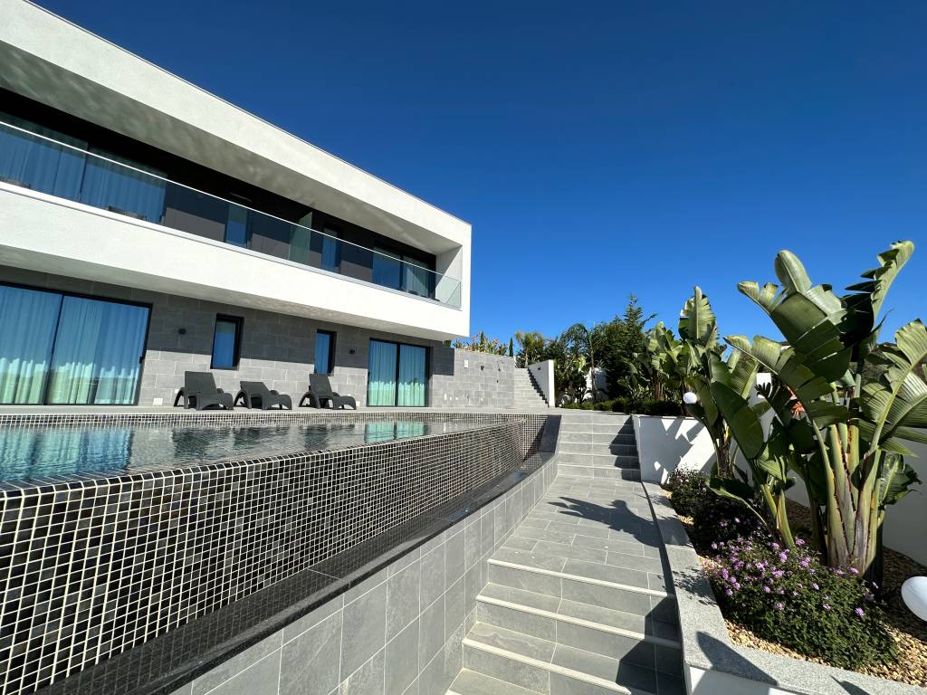 Casa de dois andares, moderna, de linhas retas, com uma piscina à frente