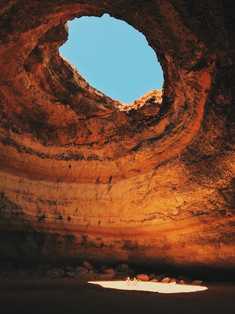 Gruta com um buraco no teto que deixa ver o céu e passar o sol, onde se chega apenas pelo mar