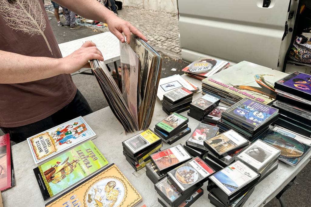 Uma pessoa pesquisa discos de vinil numa barraca da Feira da Ladra