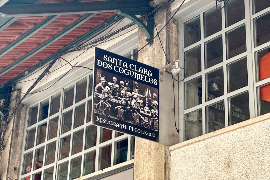 Placa do restaurante Santa Clara dos Cogumelos, na fachada do mercado de Santa Clara