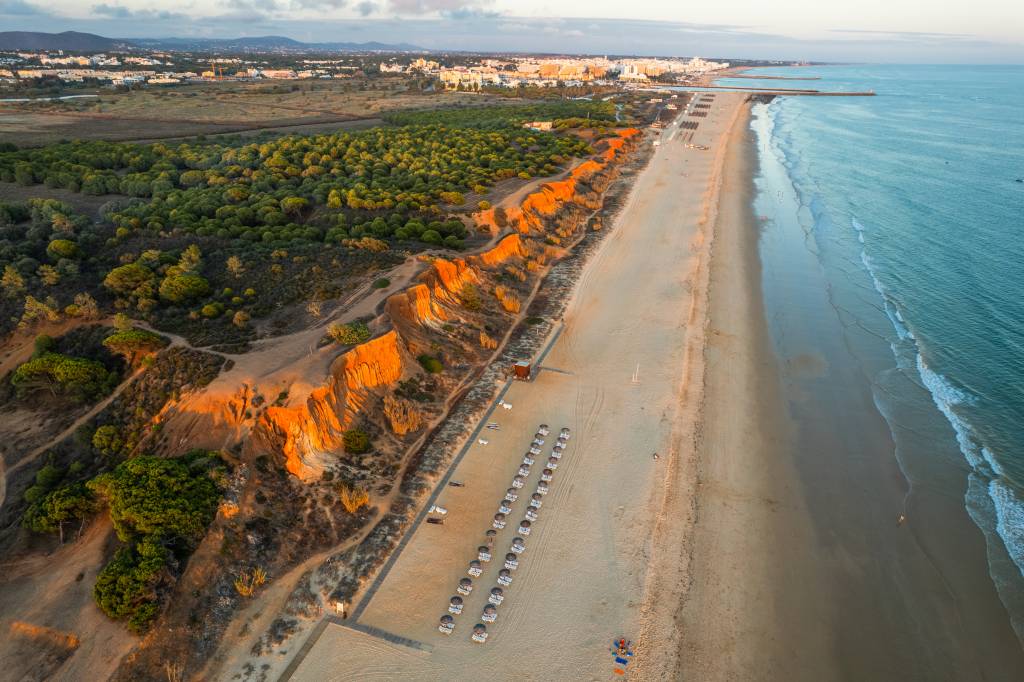 Praia da Falesia, Algarve beach in Albufeira, Portugal. Aerial d Fotografia colorida aérea mostra a praia eleira a melhor do mundo do alto, destacando suas falésias coloridas cobertas por pinheiros