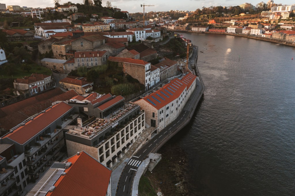 Fotografia aérea mostra ao rio Douro e a margem de Vila Nova de gaia com o hotel The Rebello em detaque