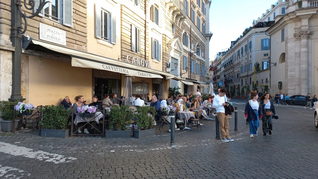 Piazza del Popolo: alguns bebem café, outros saem para a passeggiata