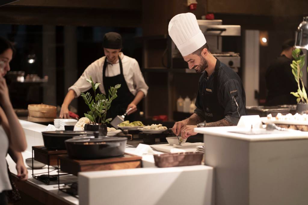 Chefs do restaurante asiático Spices em ação: cozinha ao vivo atrás do balcão