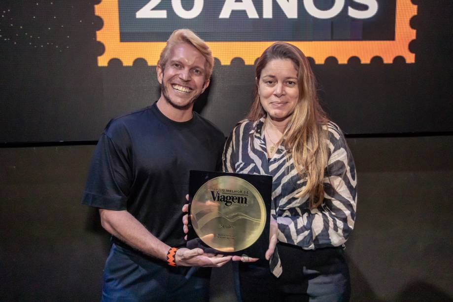 Carla Fonseca, CEO da Smiles e VP da Gol, e Diego Tranquellim, gerente de marketing da Smiles, recebem o prêmio de Melhor Programa de Milhas Nacional