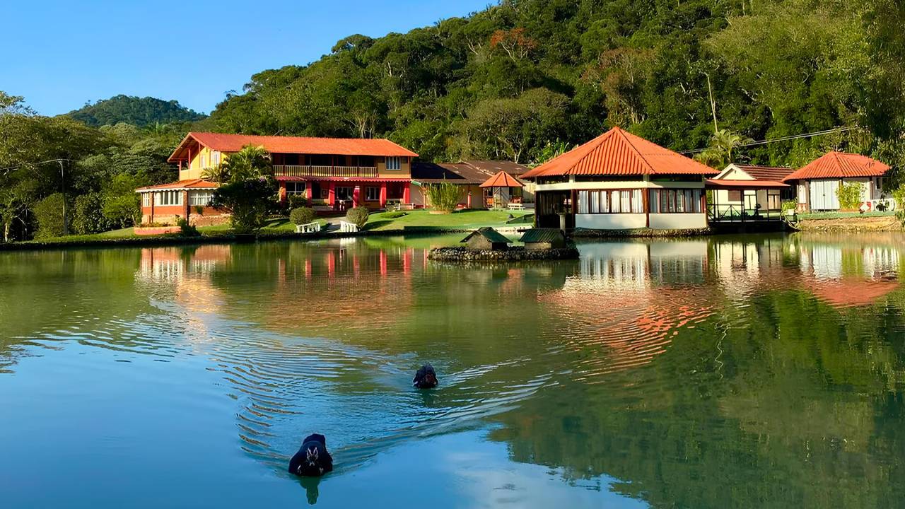 Em meio ao verde da serra, condomínio com lago abriga uma das hospedagens indicadas
