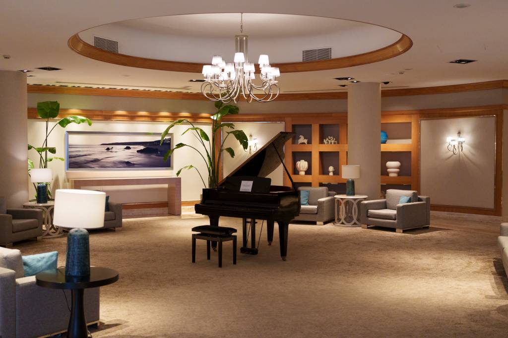 _1NC8703 Lobby interior de um hotel, com um piano ao centro e sofas ao redor