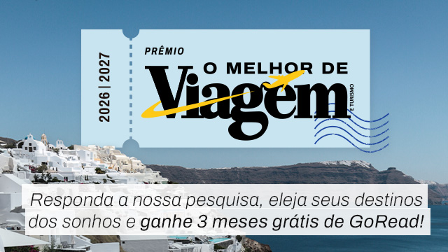 Cenário de Santorini, Grécia, com casas brancas em uma colina e o mar azul. Sobreposto, um bilhete azul claro com o texto Prêmio O Melhor de Viagem e Turismo 2026 | 2027, com um avião amarelo. Abaixo, a frase Responda a nossa pesquisa, eleja seus destinos dos sonhos e ganhe 3 meses grátis de GoRead